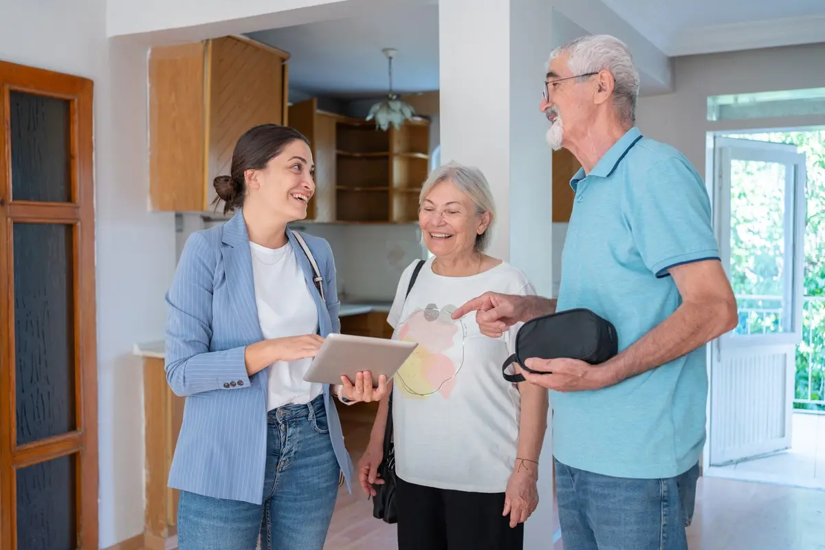 Questions to Ask on a Memory Care Tour as a senior couple reviews a care and housing plan with a professional